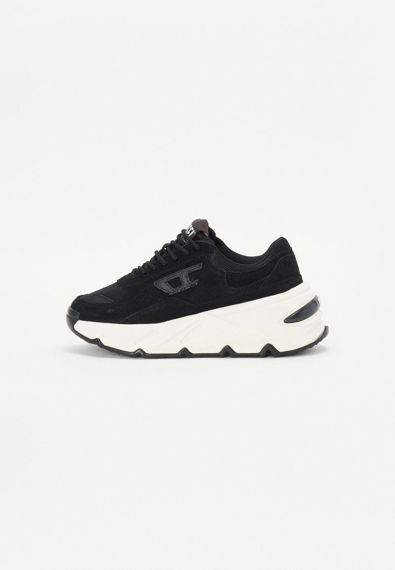 Black sneaker with a mix of mesh and suede material, featuring a chunky white sole, textured accents, and black laces.