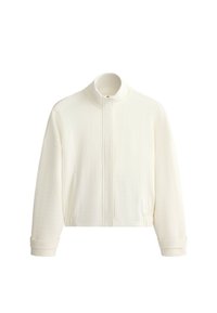 Veste blanche texturée à manches longues avec col montant, fermeture zippée à l'avant, taille élastique et détails aux poignets.