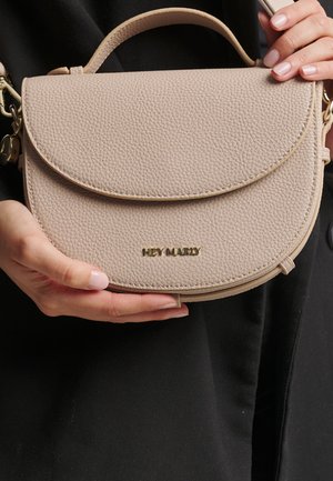 Light beige textured leather crossbody bag with a rounded flap, top handle, gold "HEY MARLY" logo, and detachable shoulder strap.