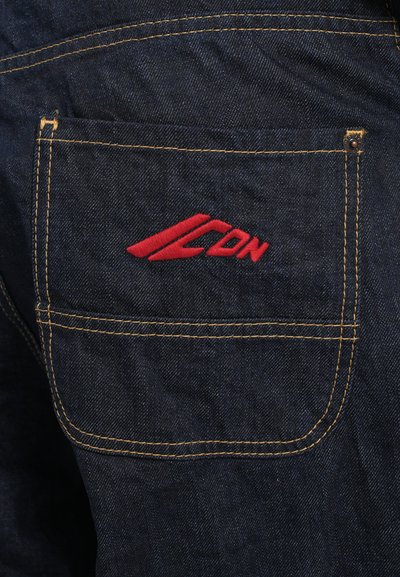 Temno modri denim z kontrastnim rumenim šivanjem. Rdeči logotip je prišit na zadnjem žepu. Žep vključuje zakovico in čisto robno zasnovo.