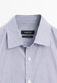 Gestreepte button-up shirt in lichtblauw en wit, met een klassieke kraag en witte knopen. Labels lezen "Massimo Dutti" en "Made in Turkije."