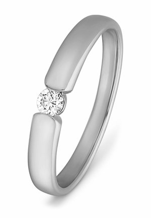 Silberner Bandring mit einem einzelnen rund geschliffenen Diamanten, der zwischen zwei offenen Enden des Rings vor einem weißen Hintergrund gefasst ist.