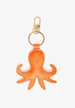 Portachiavi in pelle a forma di polpo arancione con anello e moschettone color oro, cuciture dettagliate e due piccoli occhi dorati su sfondo bianco.