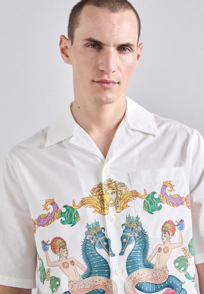 White short-sleeve shirt featuring colorful print of mermaids and sea creatures, with a fold-down collar and a left chest pocket.