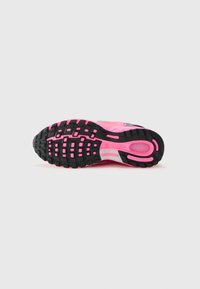 Semelle extérieure de chaussures de course Nike Air Pegasus, avec une semelle en caoutchouc noire et rose, texturée pour l'adhérence, affichant un motif de crampons distinct et des accents de logo.