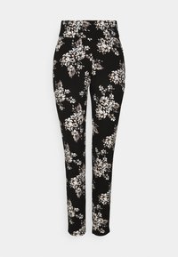 Blomstertrykkbukser i svart, med en tettsittende design, elastisk stoff og hvite og beige blomster mønstre over hele.