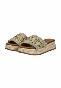 Sandalias de cuña tejidas con una amplia correa deshilachada. Colores neutros, detalles trenzados multicolores y base de plataforma de yute texturizado.