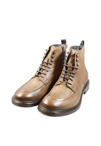 Stivaletti alla caviglia in pelle marrone con design cucito, allacciatura frontale, borchie in ottone e suola nera lucida. Dotati di anello posteriore per indossarli facilmente.