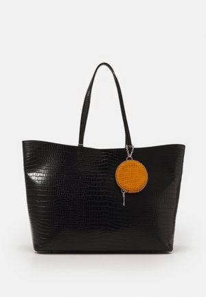 Black crocodile-embossed tote bag with two sturdy handles, featuring a round yellow zippered coin pouch attached by a silver chain.