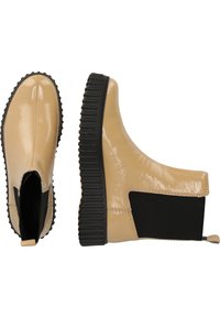 Bottes chelsea beiges brillantes avec un panneau latéral élastique noir texturé et une épaisse semelle en caoutchouc noir nervurée. Design de bout arrondi lisse.