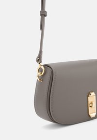 Graue Lederhandtasche mit einem eleganten, strukturierten Design. Verfügt über einen Verschluss aus gildedem Metall und einen verstellbaren Riemen für Vielseitigkeit.