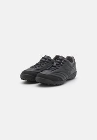 Schwarze Sportschuhe mit einer strukturierten, synthetischen Oberseite, Schnürdesign und Gummisohle mit einem Profil für besseren Grip.