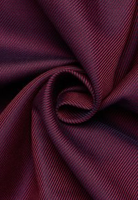 Tessuto con un motivo a righe rosso scuro e blu navy, caratterizzato da una texture liscia e una sottile tessitura a spina di pesce, elegantemente drappeggiato.