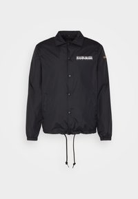 Giacca leggera in nylon nero con chiusura a scatto, polsini elasticizzati, orlo con cordino e logo stampato sul petto. Tessuto morbido.