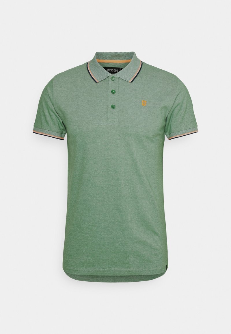 Polo vert en tissu mélangé coton. Présente un col avec des rayures noires et orange, trois boutons et un petit logo sur la poitrine.