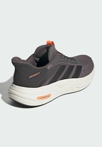 Športové tenisky v tmavo sivej sieťovine s čiernymi pruhmi a oranžovými akcentmi. Majú polstrovanú bielu gumovú podrážku a polstrovaný golier pre pohodlie.