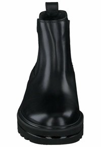 Botas de tobillo de cuero negro con un acabado suave, puntera redonda y suela gruesa. Presentan una lengüeta para facilitar el calce y detalles de costura mínimos.