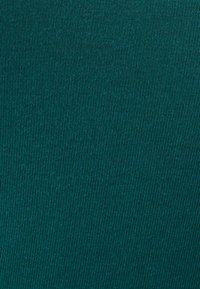 Tessuto turchese con una superficie strutturata e rigata. Il materiale appare liscio con strisce verticali; colore uniforme senza alcun motivo o accento visibile.