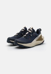 Navy blue terrengløver med mesh-overdel, beige detaljer og gummisåle. Har polstret krage og snøring for sikker passform.