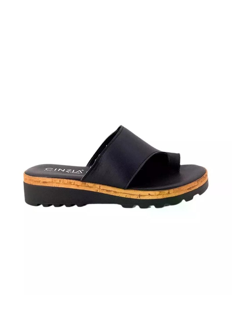 Sandal in pelle nera con una larga cinghia, accentuata da un dettaglio in sughero alla base e suola in gomma testurizzata. Design semplice con profilo piatto.