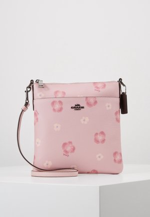 Lyserød læder Coach crossbody-taske med blomsterprint, sølvlynlås og aftagelig rem på en hvid overflade.