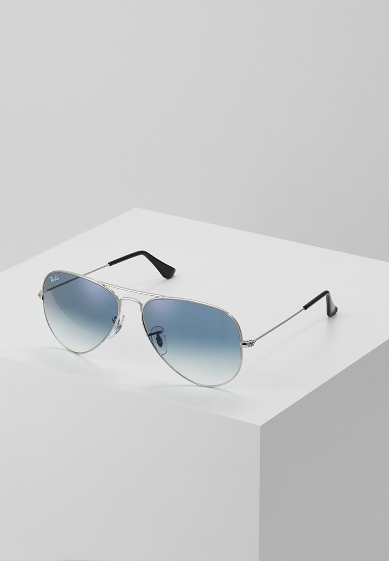 Silver aviator sunglasses with gradient blue lenses, metal frame, and black rubber tips on the arms, displayed on a white surface.