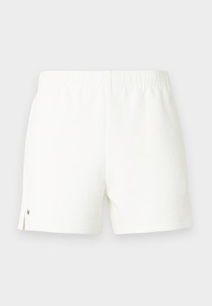 Pantalones cortos blancos de algodón con cintura elástica, que presentan pequeñas aberturas laterales y un detalle de logo verde en la parte inferior de la pierna izquierda.