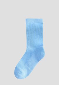 Chaussette côtelée bleu clair avec un design haut, une texture douce et un renfort au niveau des orteils, idéale pour un usage décontracté.