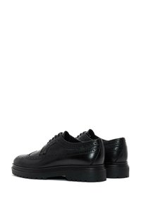 Zwarte leren oxford schoenen met brogue-details, textuurelementen, een gladde afwerking en robuuste zolen voor verbeterde grip.