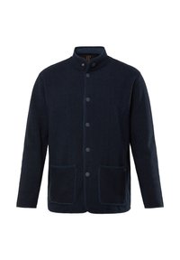 Mörkblå jacka med hög krage, knäppning i fram, två framfickor och textil med struktur. Kontrastpipning längs kanterna.