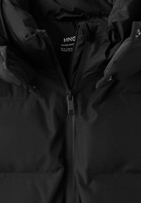 Svart puffjacka med vattenavvisande material, hög krage, dragkedja framtill och dolda tryckknappar. Slät textur med minimalistisk design.