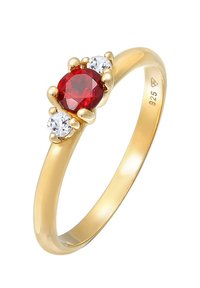 Guld ring med en central oval rød ædelsten og to runde klare sten på hver side. Glat skelet med poleret overflade og synlig stempel.