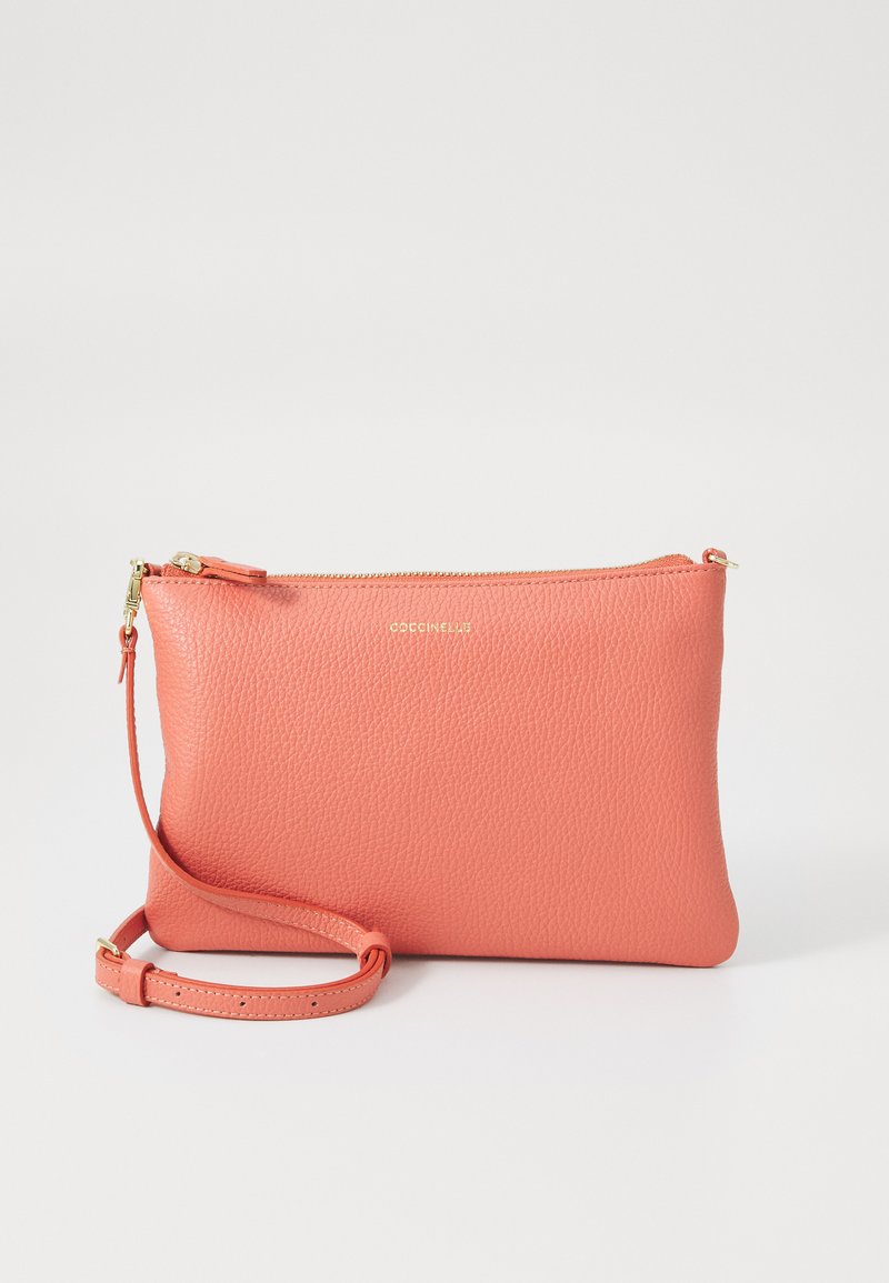 Coral leather pouch with a textured finish, gold zipper, and detachable strap. Rectangular shape, minimalistic design, mid-size.