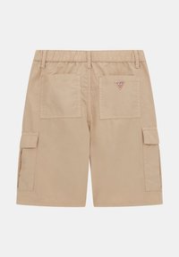 Beige cargo sortok rugalmas derékkal, két hátsó zsebbel és oldalsó cargo zsebekkel. Jellemzője egy kis piros logó folt.