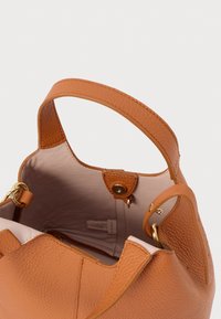 Τσάντα ώμου από δέρμα με υφή ζένας, με κοντά χερούλια, ανοιχτή κορυφή που αποκαλύπτει το μπεζ εσωτερικό επένδυση και μαγνητικό κούμπωμα.