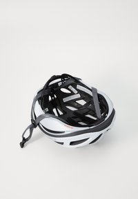 Weißer Fahrradhelm mit schwarzem Innenfutter, verstellbaren Riemen und Belüftungsöffnungen. Besondere Merkmale sind ein schlankes Design und Polsterung im Inneren.