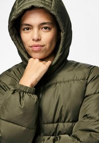 Ievilināta olīvu zaļa jaku ar kapuci, elastīgām piedurknēm un priekšējo rāvējslēdzēju. Izceļas ar izšuvumu dizainu un gludu, mirdzošu tekstūru.