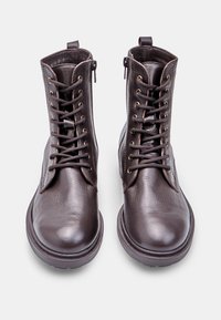 Stivali ankle in pelle marrone con finitura liscia, punta tondeggiante, allacciatura frontale e piccola cerniera laterale per una facile vestibilità.