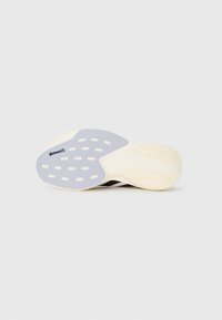 Sole of a sports shoe featuring light grey grip pads with slotted holes and a small Continental logo on a white background.