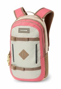 Mochila Dakine multicolor con un cuerpo crema y acentos en rosa y marrón, correas acolchadas y bolsillos con cremallera en el frente con un parche en forma de diamante.