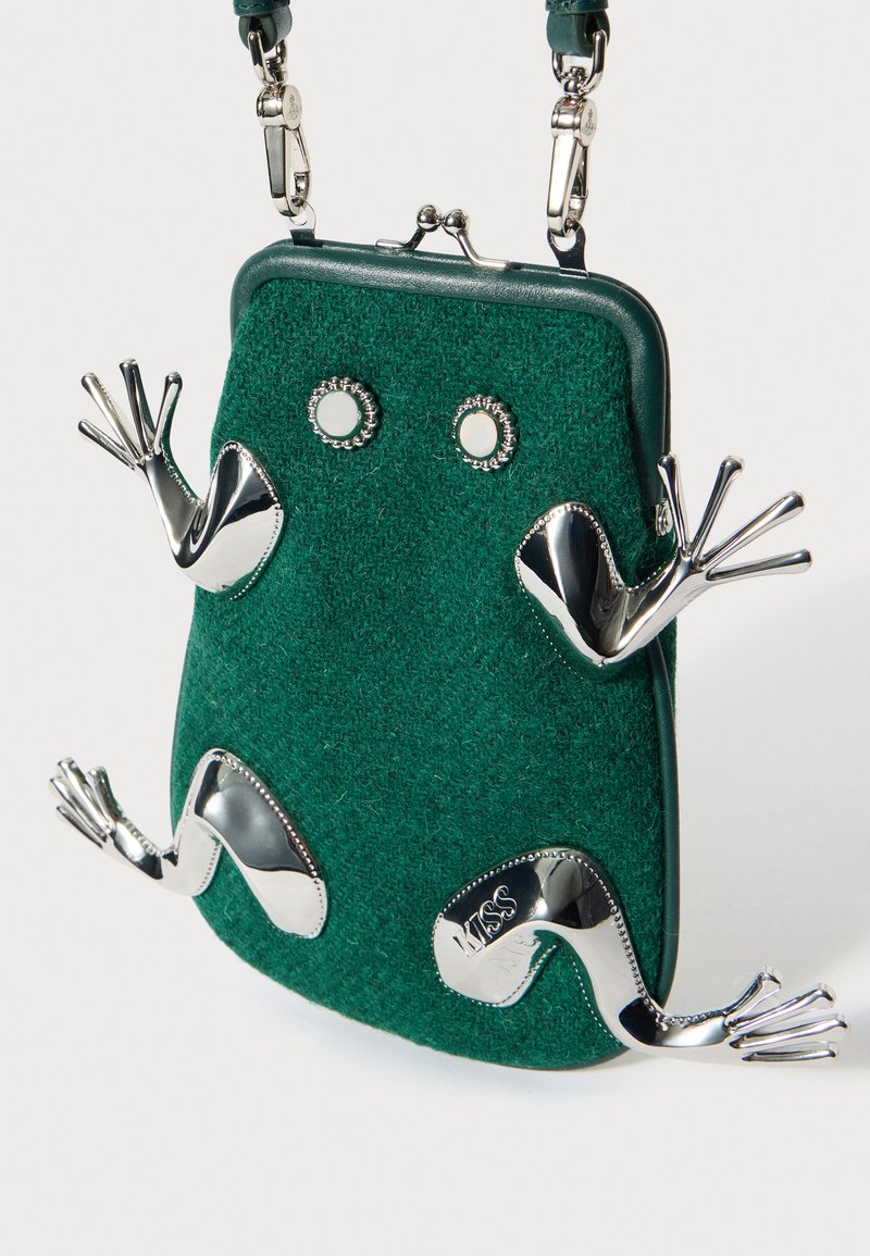 Groene vilten handtas met metalen zilveren kikkeraccenten, met een afgeronde vorm, sluiting met klikmechanisme en kleine decoratieve ogen.