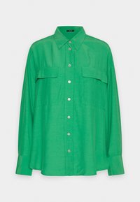 Chemise boutonnée verte en tissu léger, avec un col pointu, deux poches poitrine et des manches longues avec poignets boutonnés.