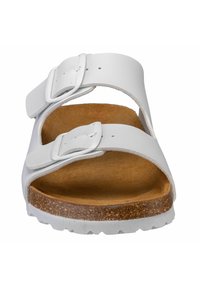 White leather sandals with two adjustable straps, brown cork footbed, and textured rubber sole. Minimalist design with no additional embellishments.