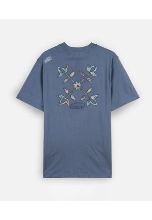 T-shirt bleu à manches courtes avec un motif central floral et feuillage dans des tons bleus et beiges, et le mot OXBOW sous le design.