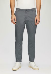 Grijze taps toelopende broek in een rekbare katoenmix; heeft een platte voorkant, zijzakken en een knoopsluiting. G gedragen met witte sneakers.