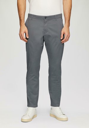Grijze taps toelopende broek in een rekbare katoenmix; heeft een platte voorkant, zijzakken en een knoopsluiting. G gedragen met witte sneakers.