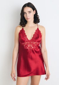 Rotes Satin-Nachthemd mit tiefem V-Ausschnitt, Spitzenrand an den Kanten und floralen Spitzendetails am Oberteil.