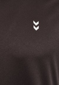 Czarny sportowy t-shirt o gładkiej fakturze z białym logo w kształcie szewronu. Materiał wydaje się lekki i przewiewny.