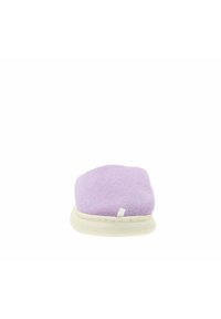 Zapatilla de casa morada de forro polar con diseño de punta redonda y suela texturizada de color crema. Presenta una pequeña etiqueta blanca en la parte superior.
