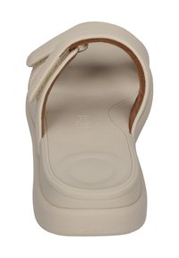Beige sandal med öppen bakdesign, med ett mjukt ovandelmaterial och dämpad sula. Velcro-remmar för justerbarhet.